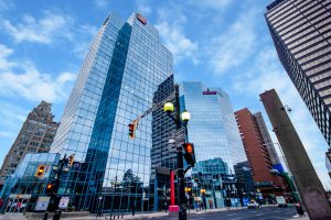 Exterior photo of Commerce Place and surrounding buildings taken from the corner of King Street and James Street North with street lights, street signs and cards in the streets.